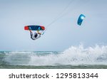 Small photo of kitesurfer athlete performing kitesurfing jump and unhooked kiteboarding tricks