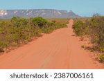 Small photo of A dirt road in the Cerrado (brazilian tropical savanna) at the Jalapao State Park, with Espirito Santo mountain ridge in the background. State of Tocantins, Brazil.