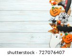 Halloween gingerbread cookies with candies on white wooden table
