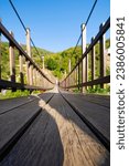 Small photo of Historical wooden suspension bridge. Adventure wooden rope suspension bridge in the rainforest. Wooden suspension bridge leading to the waterfall. Agaran Waterfall. Rize, Turkiye.