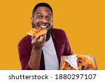 Small photo of Portrait Of Funny Black Guy Eating Pizza Slice Smiling To Camera Overeating Posing In Studio Over Yellow Background. Male Foodie Enjoying Junk Food. Unhealthy Nutrition And Cheat Meal Concept
