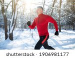 Small photo of Senior athletic man in sportswear running at winter park, copy space. Mature male runner training outdoors, jogging in nature. Seasonal outdoor sports and cold tempering concept