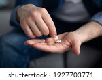 Treatment, medicine, medication, pills, vitamins, supplements concept. Unrecognizable man holding couple of pills on his palm, cropped. Closeup of male hands with medicine