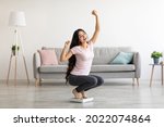 Overjoyed Indian woman sitting on scales, gesturing YES, excited over result of her weight loss diet at home. Millennial Asian lady achieving her slimming goal, copy space