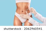 Small photo of Beauty Treatment. Cropped close up front view of young fit woman getting injection in her belly area, having procedure in salon, banner with free copy space. Doctor in gloves making jab in stomach