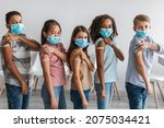 Kids Vaccination Against Covid-19. Diverse Group Of Vaccinated Children Showing Arms With Medical Plaster Bandage After Antiviral Vaccine Injection Standing Over Gray Wall Background