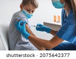 Kids Vaccination. Nurse Injecting Covid-19 Vaccine Vaccinating Boy In Arm For Virus Protection In Clinic. Preteen Child Getting Vaccinated Against Coronavirus Wearing Face Mask. Cropped