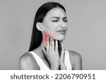 Small photo of Black and white photo of young sick lady suffering from tonsillitis, pulping her lightened in red neck, experiensing acute throat pain, copy space, closeup