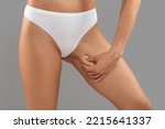Small photo of Liposuction Concept. Slim Woman In White Panties Touching Inner Thigh Skin, Unrecognizable Young Female In Underwear Enjoying Result Of Slimming, Standing Isolated On Grey Background, Cropped
