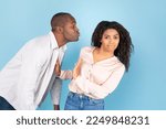 Small photo of Stay away from me. African american couple, middle aged man in love reaching and trying to kiss confused young woman, lady rejecting him and showing stop sign gesture, blue studio background