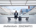 Small photo of Young Black Businessman Using Laptop While Sitting On Bench At Modern Airport Terminal, African American Male Entrepreneur Working On Computer While Waiting For His Flight Departure, Copy Space