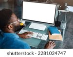 Unrecognizable black businessman using computer with empty blank screen, sitting at workplace in office, offering space for mockup on monitor. Male CEO showing place for online ad