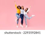 Female friendship concept. Joyful diverse ladies embracing and having fun, smiling at camera, friends posing together over pink studio background, full length, free space
