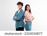 Small photo of Cheerful Young Couple Crossing Hands In Confident Gesture Smiling To Camera Standing Back To Back Over White Studio Background. Happy Friendship And Love Relationship Concept