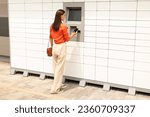 Small photo of Money Withdrawal Via Smartphone. Full Length Of Young Woman Using Atm Machine And Cellphone Instead of Credit Card, Withdrawing Currency Cash In City Outdoors, Rear View. Street Bank Machines