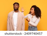 Small photo of Frustrated black woman shouting at nonchalant man, both in casual attire against vibrant yellow background in moment of disagreement