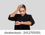 Small photo of Shocked African American businesswoman looking at her watch realizing the urgency of time, portraying a sense of late realization or deadline pressure in professional attire