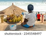 Small photo of SENEGAL, DAKAR - 04 June 2020; Young girl selling fruit in a basket on Dakar beach in Senegal, Afrika