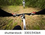 POV, Original point of view. Couple of cyclist during a mountain bike race in the forest.