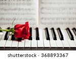 Red Rose On Piano Keys And...