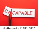 Small photo of Removing letters in from the word incapable changing it into capable. Concept of competence and skills.