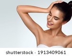 Small photo of Caucasian beautiful girl holds hair in hand, raise up hands. Beauty young woman, salon body and armpit skin care, smooth armpit skin, hair removal and sugaring. Happy girl with closed eyes