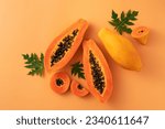 Cut papaya over orange table...