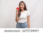 A Portrait of young asian woman holding holding red heart shape over white background studio