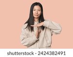Small photo of Young Chinese woman in studio setting showing a timeout gesture.