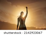 Small photo of will power. Strong young woman high on a mountain with fist up to the sky feeling inspired victorious. Double exposure.