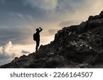 Small photo of Man getting ready to climb up mountain looking up at the challenge before him planning path. Believe in yourself, overcoming challenges, pushing forward concept.