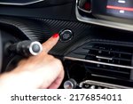 Female finger on the button to activate car engine