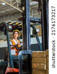 Small photo of women worker at forklift driver happy working in industry factory logistic ship. Woman forklift driver in warehouse area.