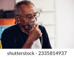 Small photo of Elderly Senior Man wear oxygen inhaler device for helping breath respiratory. Patient use portable oxygen at home. Patients with respiratory disorders. portable oxygen concentrator or oxygen generator