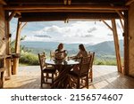 Сouple in love have breakfast in a bamboo house overlooking the mountains. Fruits, tea or coffee overlooking the mountains in Bali.