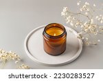 Small photo of Handmade candle from paraffin and soy wax in glass jar on concrete tray. Candle making. Minimalism. Luxurious white tray decoration, home interior decor with burning aroma candle with white dry flower