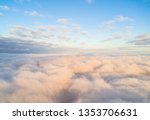 Aerial view White clouds in blue sky. Top view. View from drone. Aerial cloudscape. Texture of clouds. View from above. Sunrise or sunset over clouds
