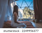 Travel vacation glamping concept, Happy traveler asian woman relax inside a luxury camping dome tent in Mon Jam, Chiang Mai, Thailand