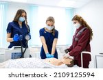 Small photo of CPR first aid with AED Training Concept. Paramedic demonstrates cardiopulmonary resuscitation on a dummy to medical students and nurses. Emergency services occupation