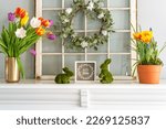 White mantel decorated for Spring with tulips and bunnies