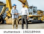Small photo of Builder choosing heavy machinery for construction, talking with a sales consultant on the open ground of a shop with special vehicles