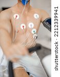 Small photo of Torso of man athlete with electrodes, testing heart system on bike simulator