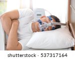 Small photo of Happy and healthy senior man wearing Cpap mask sleeping smoothly all night long on his left side cross arms without snoring.Obstructive sleep apnea therapy.