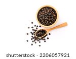 Black pepper or peppercorns in wooden bowl with spoon isolated on white background , top view , flat lay.