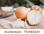 Onion and slices on wooden cutting board.