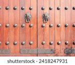 Small photo of Old Chinese style door handle on wooden door, antique oriental door knocker. Traditional Chinese doors with brass lion head door knockers