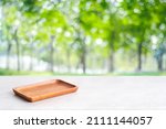 Small photo of Empty wooden plate on white table over blur green trees nature with bokeh background, Blank wood dish for food display montage banner template, muck up, poster, wallpaper