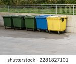 Small photo of Black, blue, yellow, green garbage recycling bins on street in city. Separate waste, preserve the environment concept. Segregate waste, sorting garbage. Colored trash cans with paper, glass, plastic