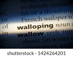 Small photo of walloping word in a dictionary. walloping concept, definition.