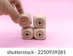 Small photo of Plus and minus icons on wooden cubes. Separate the negative from positive, removing the weaknesses or negativity, positive thinking, negative feedback or subtraction